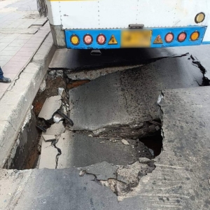 曼谷一道路突现巨坑，致公交车无法行走